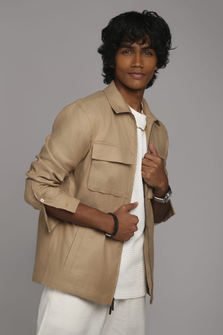 Shabs in a beige overshirt against a grey backdrop
